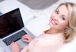 Pretty 2smiling woman using laptop Chicago Facelift Surgeon